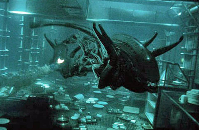 Diorama d'une créature aquatique extraterrestre cornue dans un laboratoire submergé à l'ambiance bleutée
