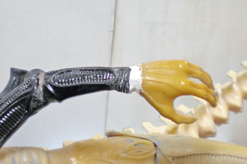 Bras noir et main griffue jaune de la maquette Aqualien assemblés avec mastic blanc
