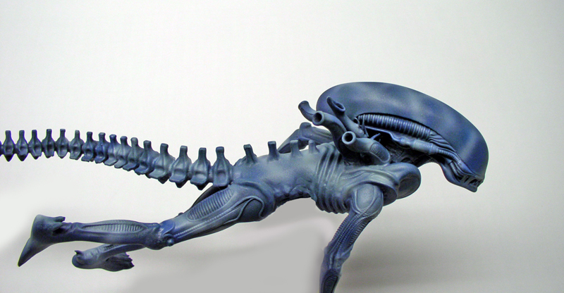 Maquette de figurine Aqualien bleu vue de profil avec longue queue segmentée et crâne allongé