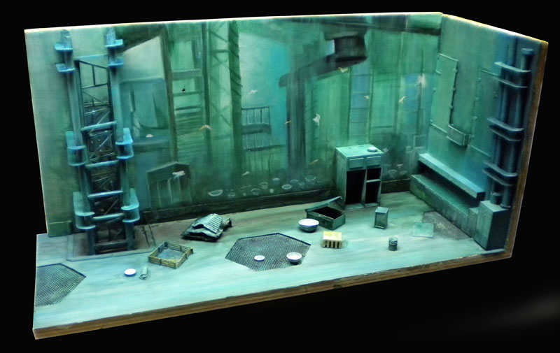 Diorama de maquette représentant une salle industrielle sous-marine aux tons verts avec décor mural détaillé