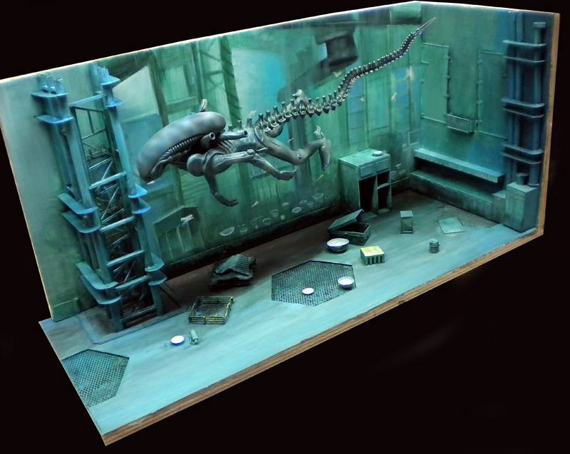 Diorama d'une créature Aqualien nageant dans une salle industrielle immergée aux tons verts et bleus