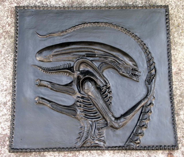 Bas relief patiné gris métallique représentant la créature Alien de profil sur plaque carrée