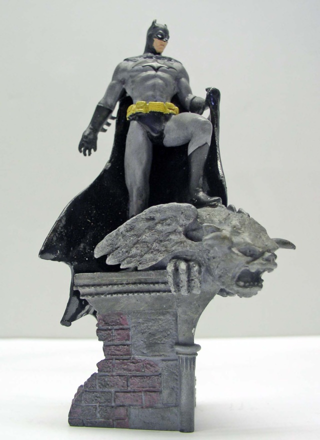 Figurine maquette de Batman debout sur une gargouille ailée perchée sur un socle de briques