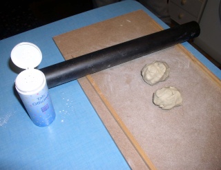 Rouleau noir et pot d'enduit pour étaler la pâte à modeler sur planche