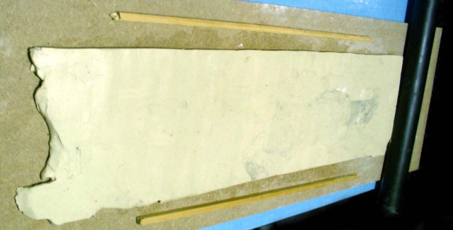 Plaque d'enduit clair en séchage pour mur de maison à colombage avec baguettes de bois