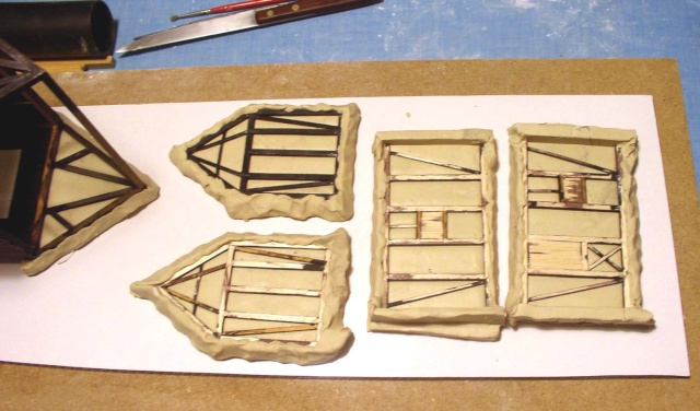 Murs de maquette à colombages en cours de fabrication, ossatures bois sur plaques d'argile