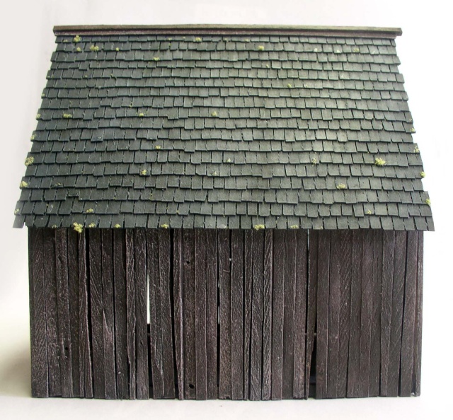 Maquette de grange médiévale avec toit en bardeaux gris et bardage bois sombre