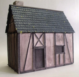 Maquette de maison à colombage médiévale avec toit en tuiles grises et porte en bois