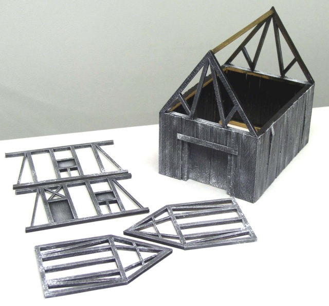 Maquette de grange médiévale en bois avec charpente apparente et pans de colombage démontés