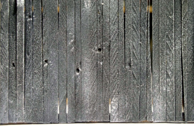 Bardage de planches de bois gris vieilli formant le mur d'une grange médiévale miniature