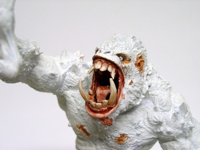 Figurine de créature simiesque blanche gueule ouverte montrant crocs, peinture détaillée de la bouche