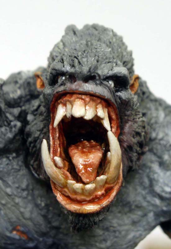 Gros plan sur la tête peinte d'une figurine de gorille géant rugissant, gueule ouverte