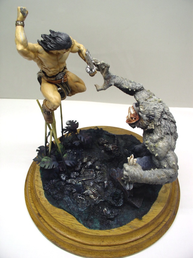 Diorama de Conan bondissant attaquant une créature simiesque grise sur socle bois
