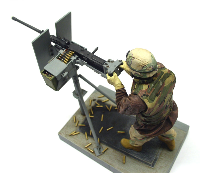 Diorama d'un servant en tenue camouflée servant une mitrailleuse Browning M2 sur trépied