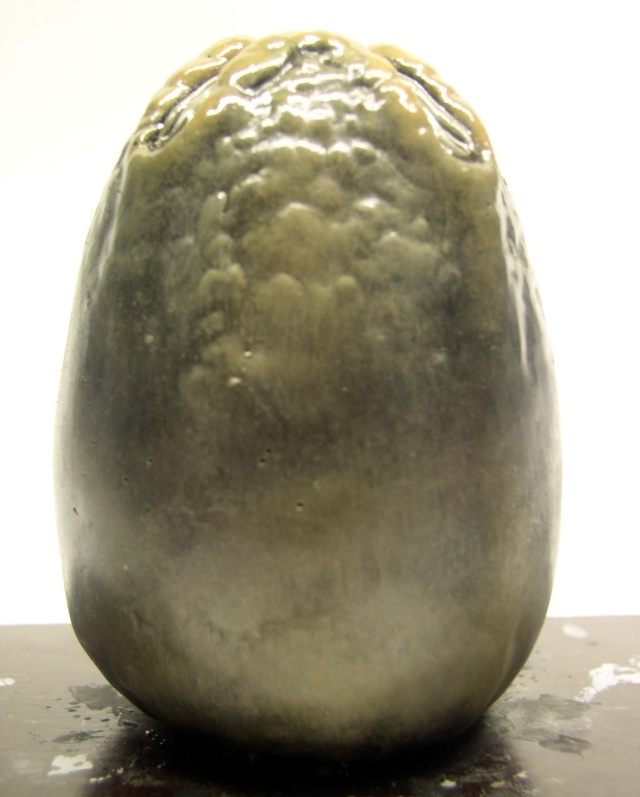 Œuf d'Alien peint en vert olive avec sommet vernis brillant en cours de peinture
