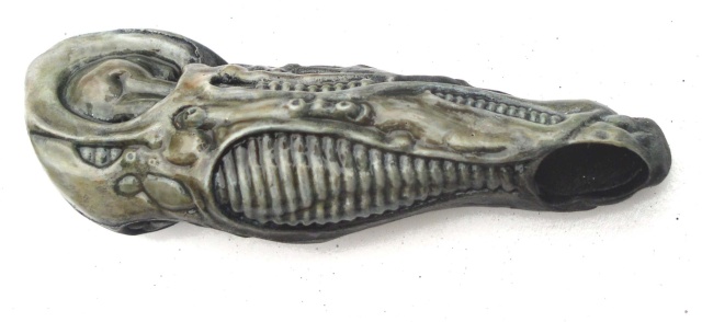 Tête allongée de la créature Alien peinte en tons gris verdâtre, vue de profil