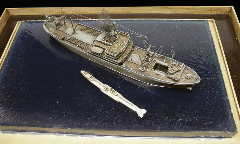 Maquette de Liberty ship et sous-marin miniature dans un diorama sur mer sombre