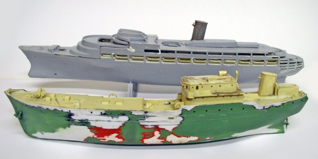 Maquettes de deux navires en cours de montage, coque grise et coque verte au camouflage