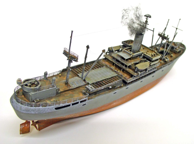 Maquette de Liberty ship gris à coque rouille avec mâts, grues et fumée s'échappant de la cheminée