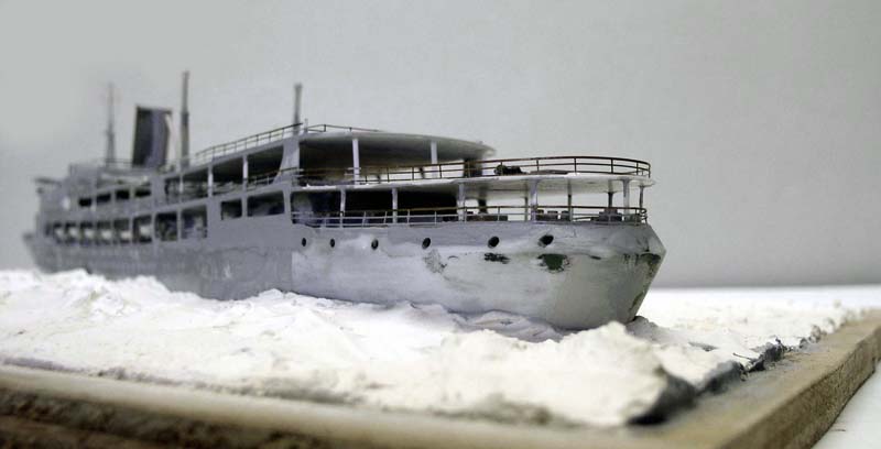 Maquette de navire fantôme gris échoué dans la glace sur un diorama enneigé