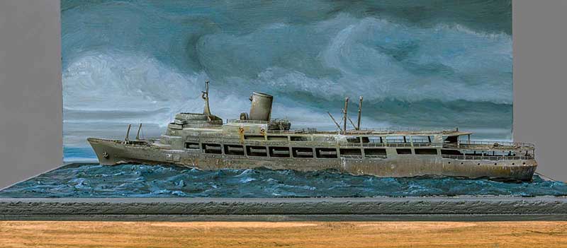 Maquette de navire fantôme vieilli naviguant sur une mer agitée devant un ciel orageux peint