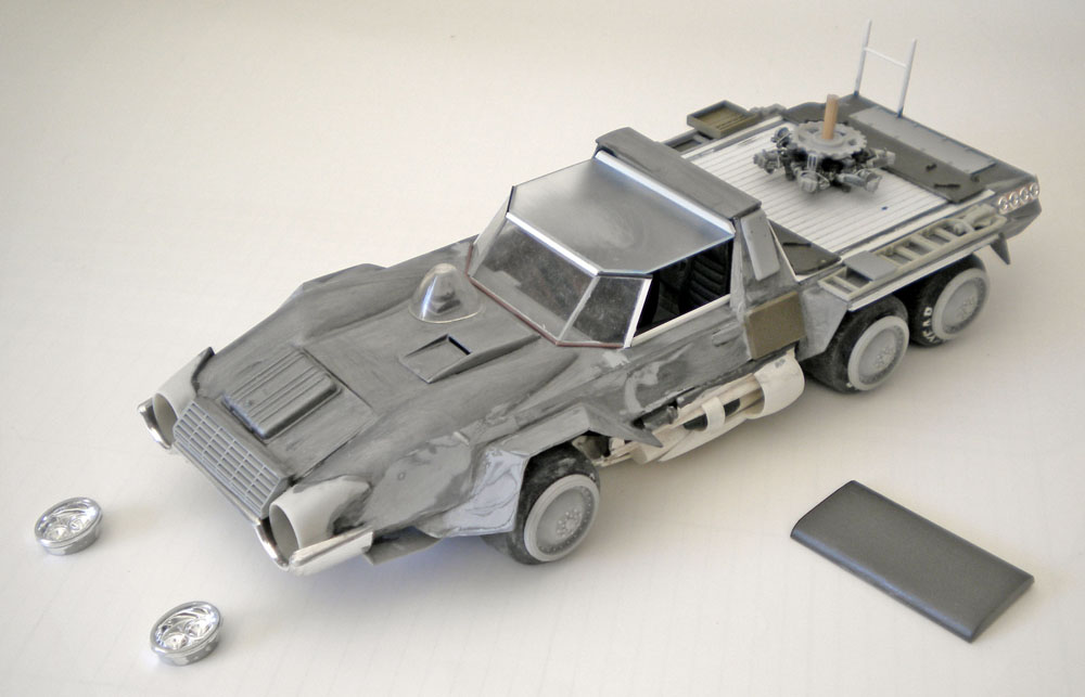 Maquette en cours de montage d'un véhicule blindé futuriste gris avec pièces détachées