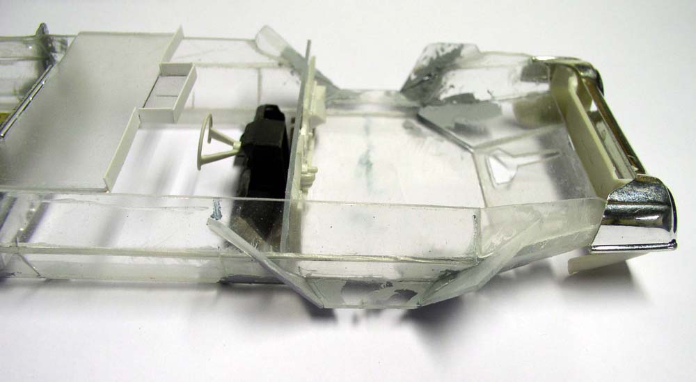 Maquette de véhicule en plastique transparent avec volant et habitacle en cours d'assemblage