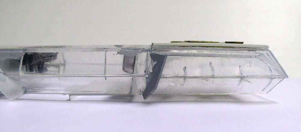 Maquette d'engin futuriste en plastique transparent en cours d'assemblage, vue de profil