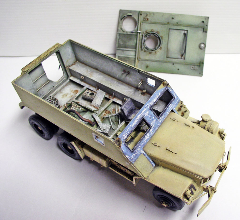 Maquette de Guntruck militaire avec plateau blindé ouvert et plaque de protection détaillée en arrière-plan