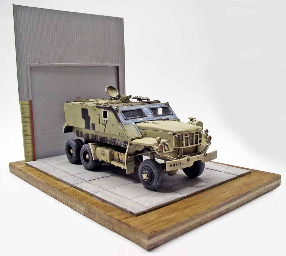 Maquette de Guntruck militaire blindé sable sur diorama avec dalles béton et mur gris