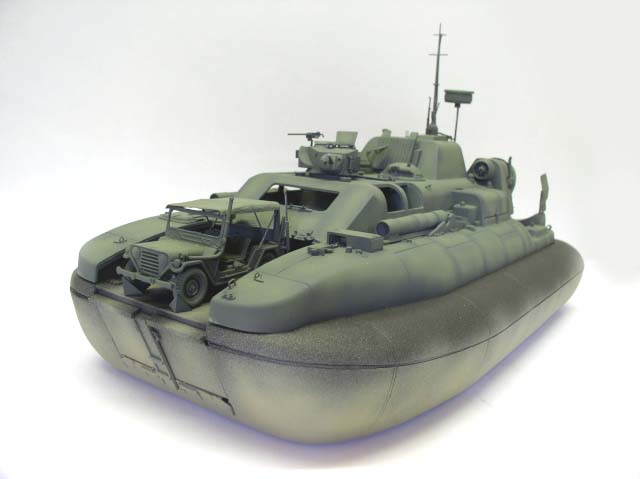 Maquette d'hovercraft militaire vert avec jeep et mitrailleuse à bord, vue trois-quarts