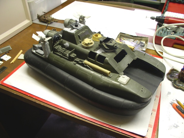 Maquette d'hovercraft militaire vert olive en cours de montage sur l'établi du modéliste