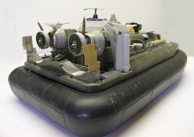 Maquette d'hovercraft militaire en cours d'assemblage montrant moteurs, ventilateurs et jupe noire