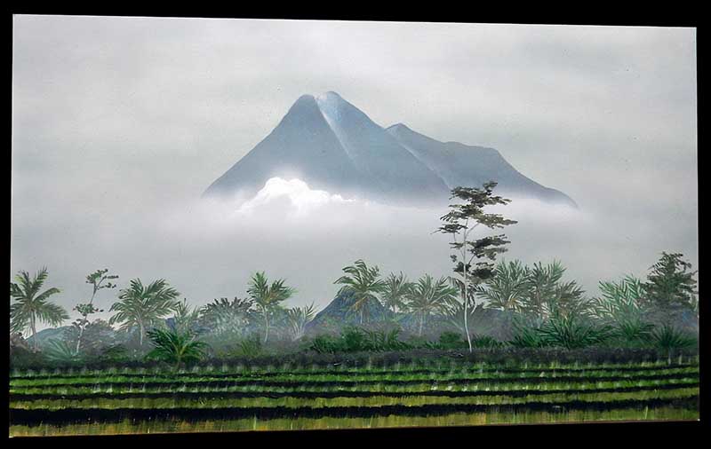 Décor de diorama peint montrant une montagne brumeuse dominant rizières et palmiers du paysage vietnamien