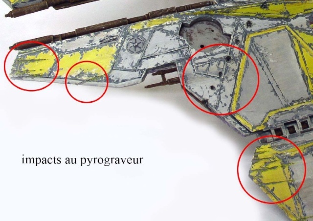 Maquette de vaisseau spatial jaune et gris avec impacts au pyrograveur cerclés de rouge