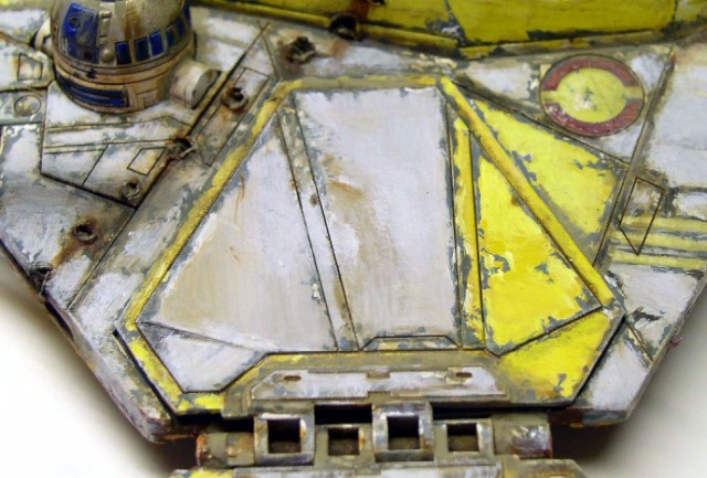 Détail du fuselage vieilli d'un chasseur spatial avec droïde astromécano et peinture jaune écaillée