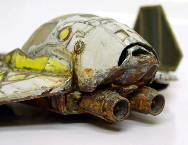 Maquette d'épave de vaisseau spatial au cockpit endommagé, fuselage rouillé et marquages jaunes