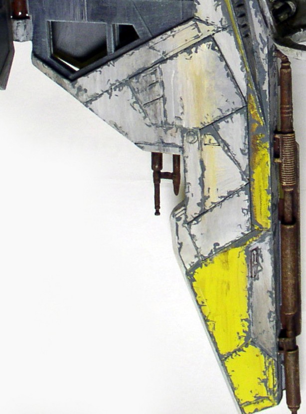 Détail de l'aile grise et jaune vieillie de la maquette d'épave de vaisseau spatial
