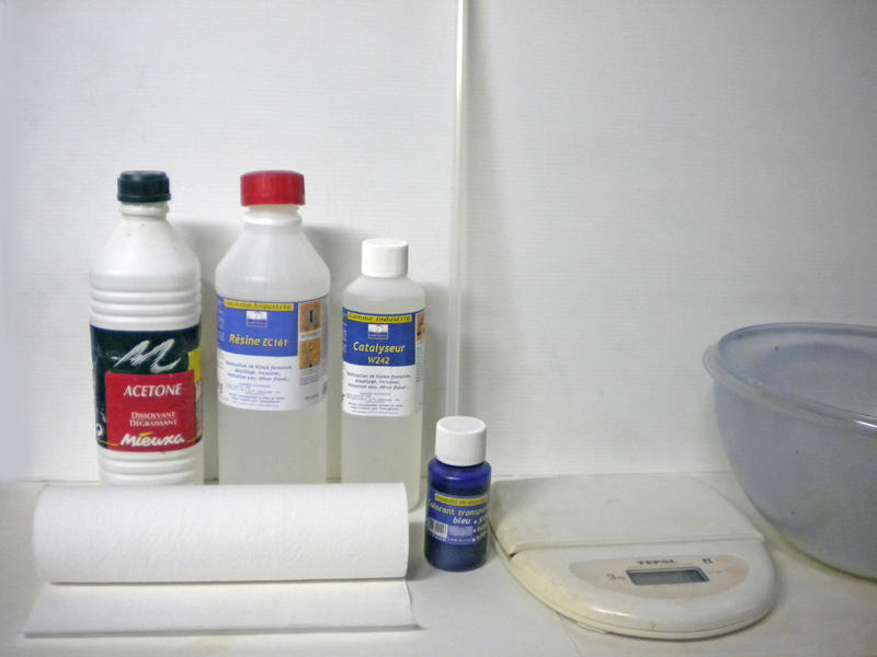 Flacons de résine, catalyseur, acétone, colorant bleu, essuie-tout et balance pour couler l'eau