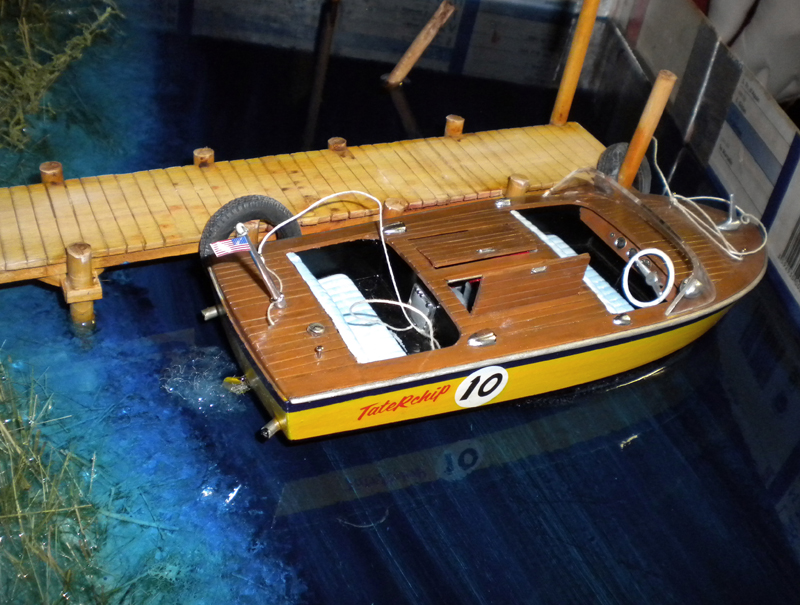 Maquette de bateau en bois amarrée au ponton sur eau en résine d'un diorama