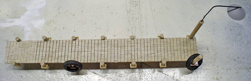 Maquette d'un quai en bois sur diorama avec lampadaire et bornes d'amarrage