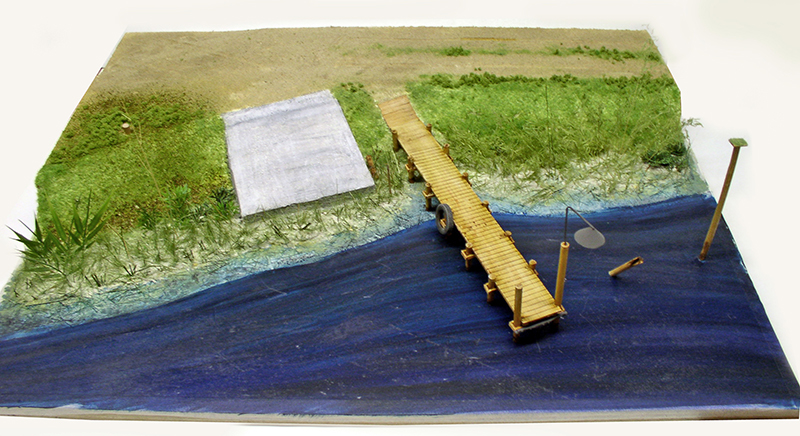 Diorama avec ponton en bois s'avançant sur une rivière en résine bleue
