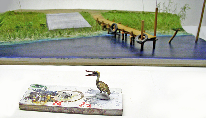 Diorama avec eau en résine et ponton, figurine d'oiseau peinte au premier plan