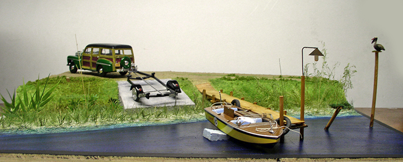 Diorama avec voiture woody, remorque et barque amarrée à un ponton sur l'eau en résine