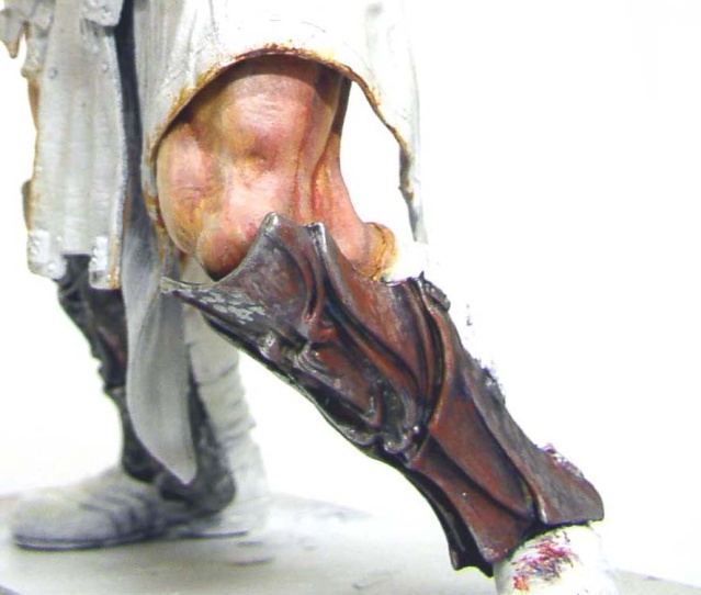 Gros plan sur la jambe peinte d'une figurine 180 mm avec patte griffue et tissu blanc
