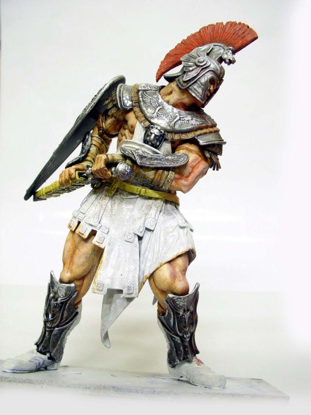 Figurine de gladiateur romain peinte avec casque à crête rouge, bouclier et armure argentée