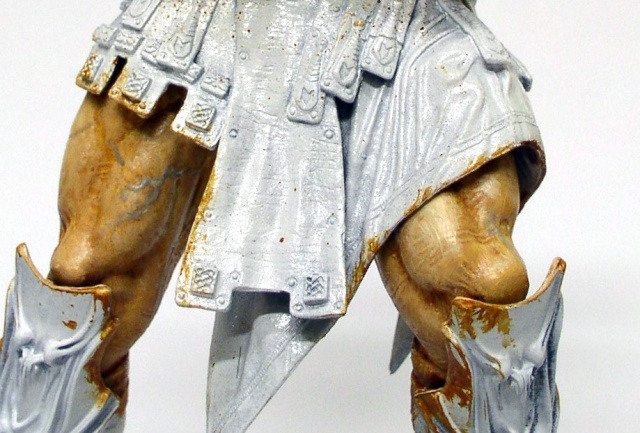 Détail des cuisses et de la jupe d'armure argentée d'une figurine McFarlane en cours de peinture