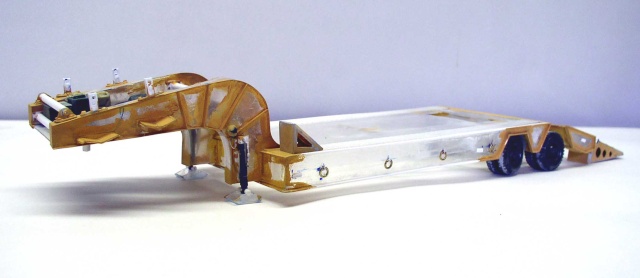 Maquette de remorque surbaissée porte-engins avec col de cygne doré et essieux arrière sur fond clair