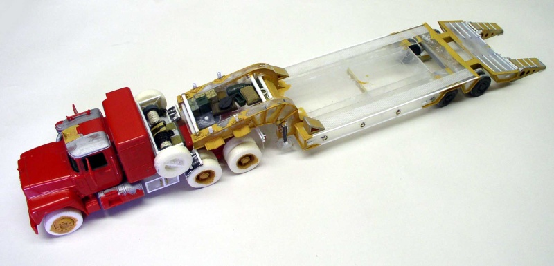 Maquette de camion Mack rouge attelé à une remorque porte-engins surbaissée en construction