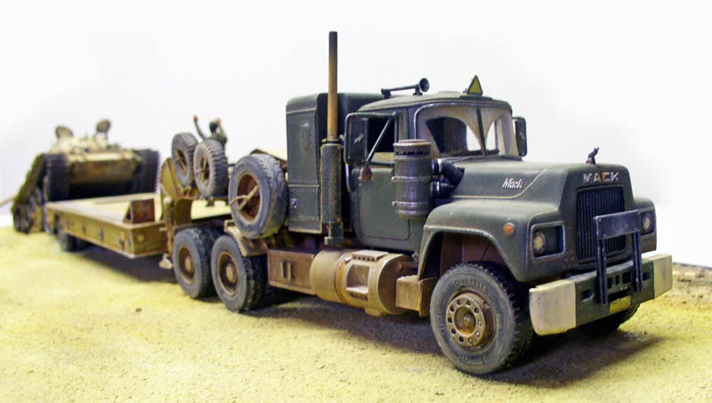 Maquette de camion militaire Mack vert tractant une remorque porte-char chargée d'un blindé